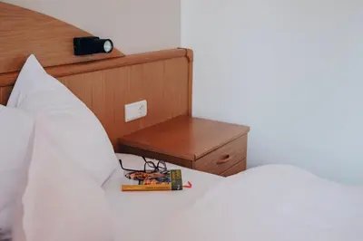 a bedroom with a bed with a book and a night stand at Apartment Steinbach in Schenna