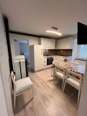 a kitchen with a table and chairs in a room at Abete Bianco in Mezzano