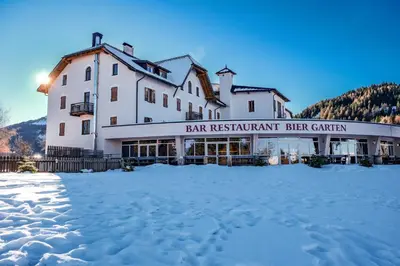 a large white building with snow in front of it at Hotel Pietralba in Madonna di Petralba
