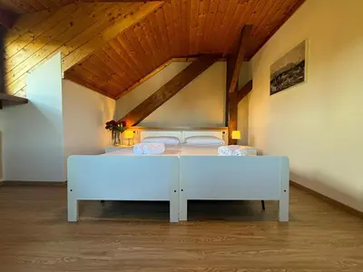 a white bed in a room with a wooden ceiling at Hotel Pietralba in Madonna di Petralba