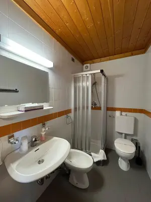 a bathroom with a sink and a toilet and a shower at Hotel Pietralba in Madonna di Petralba