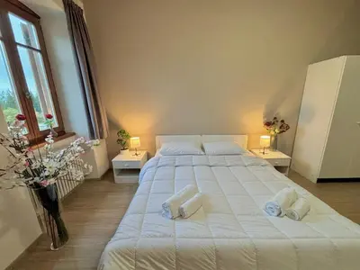 a bedroom with a large white bed with two towels at Hotel Pietralba in Madonna di Petralba