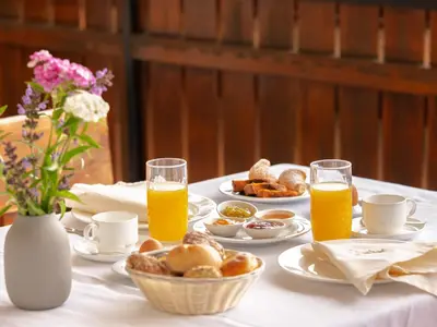 a table with a breakfast of orange juice and pastries at Garni Praidlerhof in Tirolo