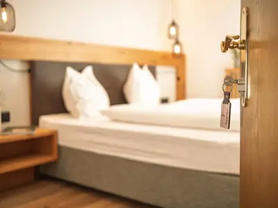 a bedroom with a bed with white pillows at Garni Praidlerhof in Tirolo