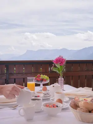 a table with breakfast foods and drinks on a balcony at Garni Praidlerhof in Tirolo