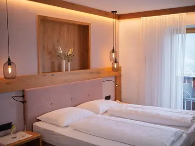 two beds in a bedroom with a mirror above them at Garni Praidlerhof in Tirolo