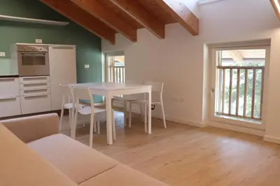 a kitchen and dining room with a table and chairs at Casa Dusinei Blue & Green in Cles