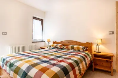 a bedroom with a bed with a striped comforter at Trilo Fiéma in Panchia