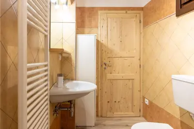 a bathroom with a white sink and a door at Trilo Fiéma in Panchia