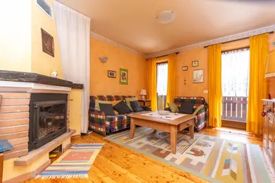 a living room with a fireplace and a table at Col da Daut 8 in Rocca Pietore
