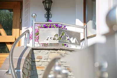 a stairway with purple flowers in a planter at Pension Alpenhof B&B in Colle Isarco
