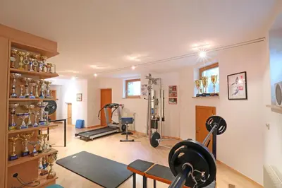 a room with a gym with equipment in it at Pension Alpenhof B&B in Colle Isarco