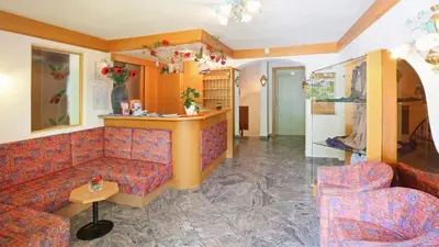 a living room with a couch and a table at Pension Alpenhof B&B in Colle Isarco