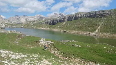 a person walking on a hill next to a river at Cedepuent de Sot in Selva di Val Gardena