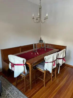 a dining room table with chairs and a chandelier at Villa Istria Apartment in San Vito di Cadore