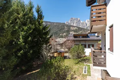 a view from the balcony of a house with mountains in the background at Chalet Baranci in Pozza di Fassa