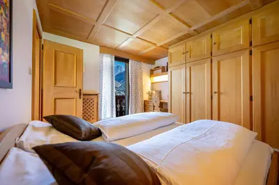 a bedroom with two beds and a wooden ceiling at Panorama Apartments Walter in Ortisei