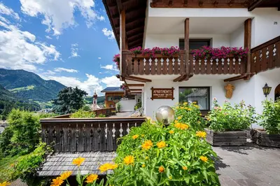 a house with a balcony with flowers on it at Panorama Apartments Walter in Ortisei