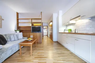 a kitchen and living room with a couch and a table at Panorama Apartments Walter in Ortisei