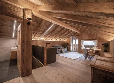 a large room with wooden ceilings and a dining room at Ciasa Somuer in San Vigilio Di Marebbe