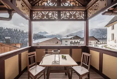 a table and chairs in a room with a large window at Ciasa Somuer in San Vigilio Di Marebbe