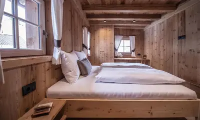a bedroom with a bed in a wooden cabin at Ciasa Somuer in San Vigilio Di Marebbe