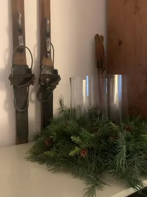 a table with a christmas arrangement of pine needles at DHome in Agordo