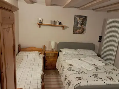 a bedroom with two beds and a shelf on the wall at Casa Anelis in Bedollo