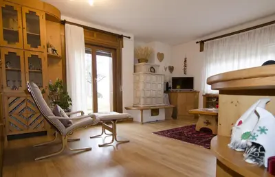 a living room with a chair and a table at Ciasa Nina in San Vito di Cadore