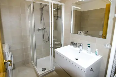 a bathroom with a shower and a sink and a shower at Ciasa Nina in San Vito di Cadore
