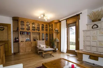 a living room with wooden cabinets and a chair at Ciasa Nina in San Vito di Cadore