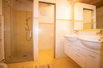 a bedroom with a bed and a desk in it at Casa Podestà in Moena