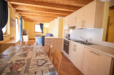 a kitchen with white cabinets and a counter top at Casa Podestà in Moena