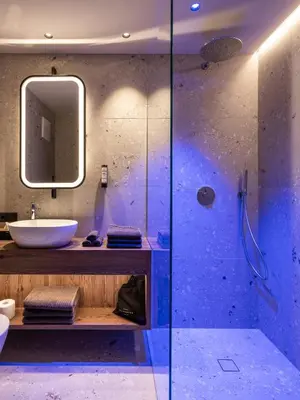 a bathroom with a glass shower and a sink at Corones Suites - Dolomites Residence in Valdaora