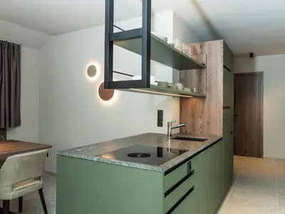 a kitchen with a sink and a counter at Corones Suites - Dolomites Residence in Valdaora