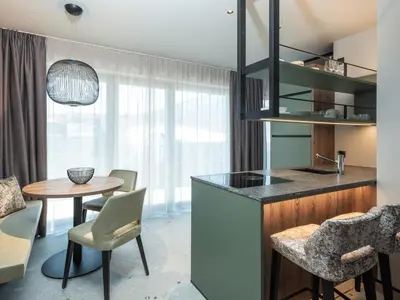 a kitchen and dining room with a table and chairs at Corones Suites - Dolomites Residence in Valdaora