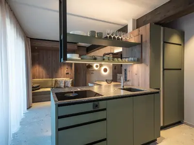a kitchen with a sink and a refrigerator at Corones Suites - Dolomites Residence in Valdaora