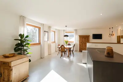 a kitchen with a table and a dining room at Birchboden Lodge in Longomoso