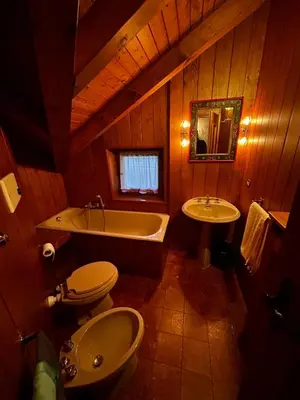 a bathroom with a tub and a toilet and a sink at Villa Serena in San Vito di Cadore