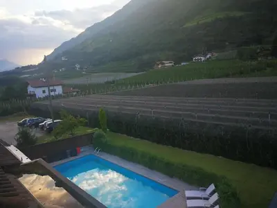 a swimming pool in a yard with a mountain at Hotel Mondschein in Plaus