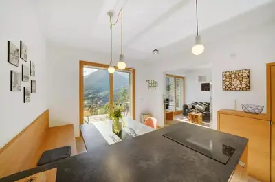a dining room and living room with a black table at Dahoam - Vistasuite in Schenna