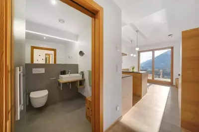 a bathroom with a white toilet and a sink at Dahoam - Vistasuite in Schenna