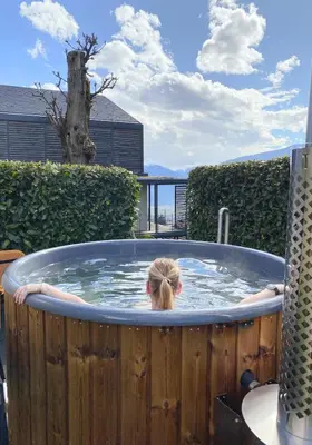 a woman is in a jacuzzi in a backyard at Dahoam - Vistasuite in Schenna