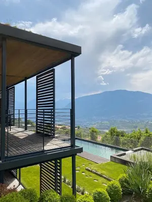 a house with a balcony with a view at Dahoam - Vistasuite in Schenna