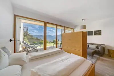 a bedroom with a large bed and a large window at Dahoam - Relaxsuite in Schenna
