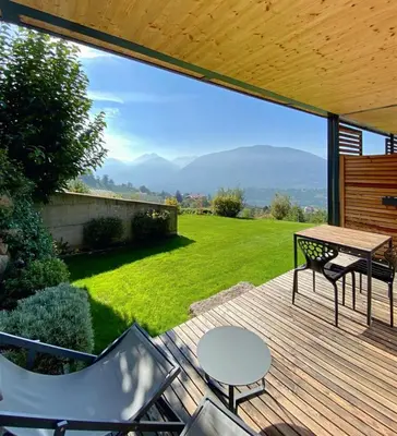 a patio with a table and chairs on a deck at Dahoam - Relaxsuite in Schenna