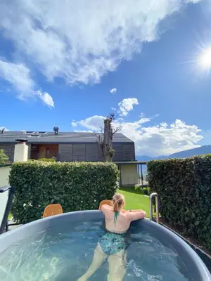 a woman sitting in a hot tub in a backyard at Dahoam - Relaxsuite in Schenna