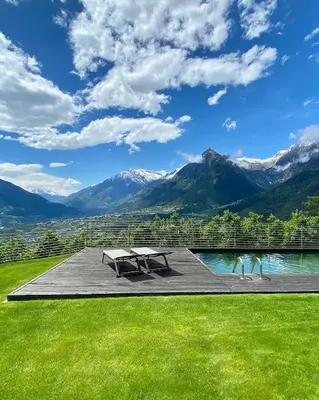 a patio with a view of mountains and a lake at Dahoam - Relaxsuite in Schenna