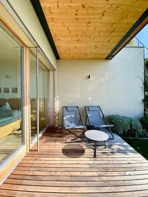 two chairs and a table on a wooden deck at Dahoam - Relaxsuite in Schenna