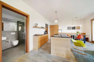 a kitchen with a table and a yellow chair at Dahoam - Panoramasuite in Schenna